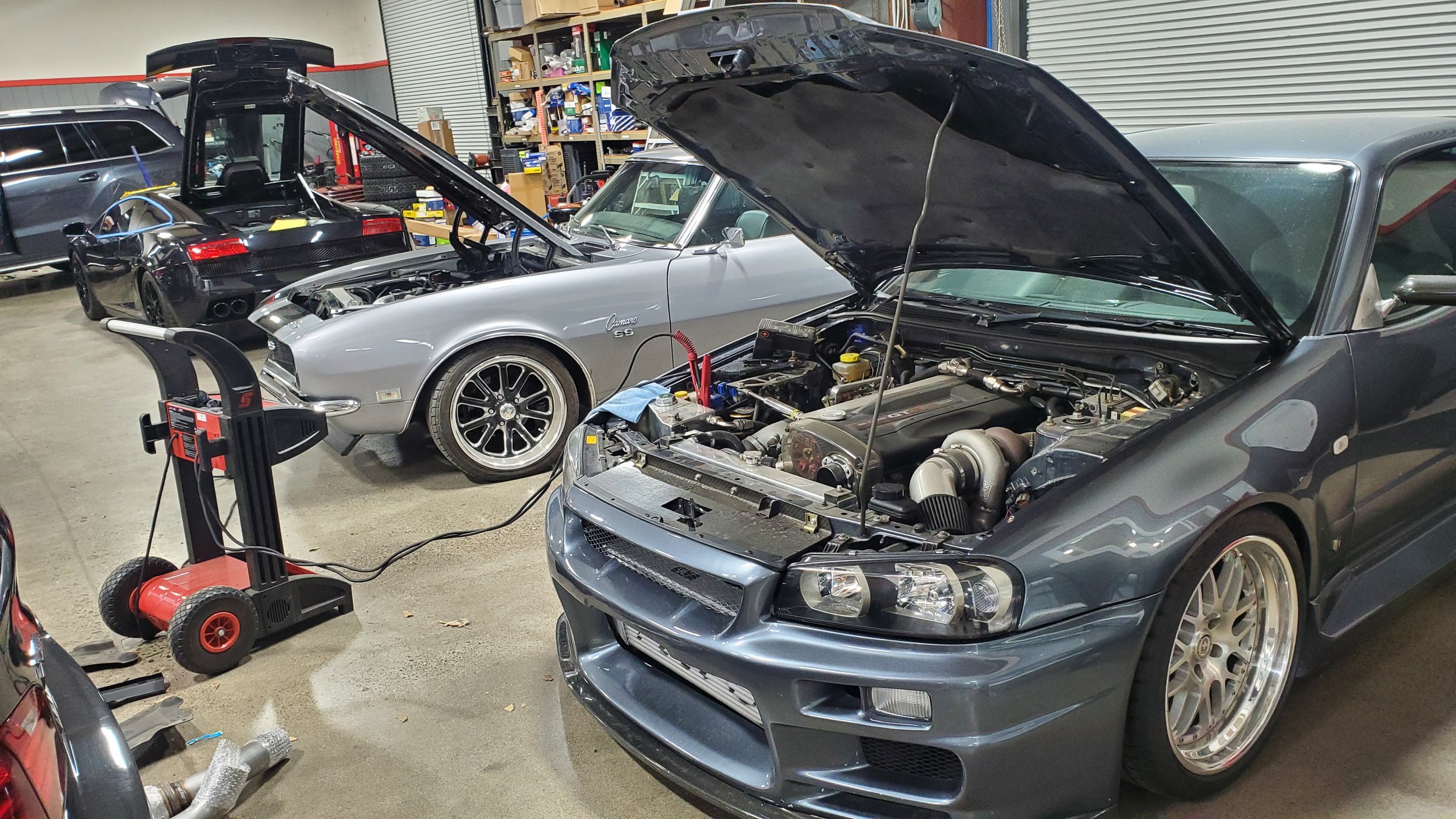 Three European cars with hoods open