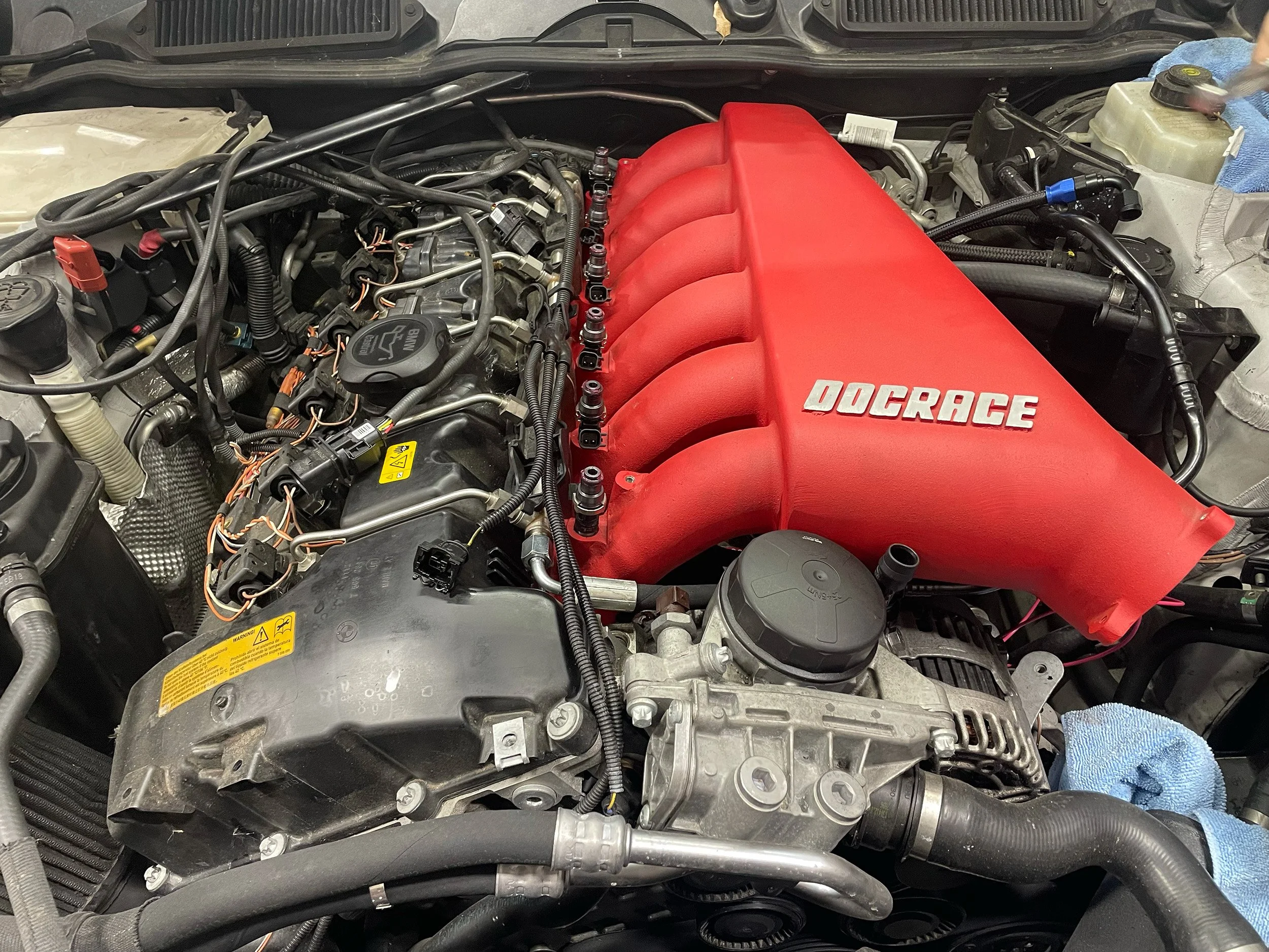 Aftermarket header being installed on a BMW at NW Autohaus